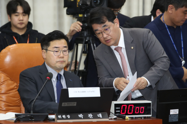 박찬대(왼쪽) 국회 운영위원장과 여당 간사인 배준영 국민의힘 의원이 19일 오후 서울 여의도 국회에서 열린 운영위원회 전체회의에서 대화하고 있다. 뉴스1