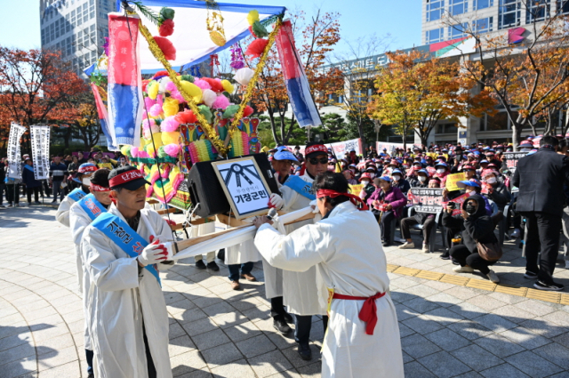 21일 부산시청에서 기장군민들이 부산시의 도시계획조례 개정을 반대하는 상여시위를 벌이고 있다. 개정 조례안은 당초 구청장·군수에게 위임됐던 묘지공원·폐기물처리시설 등 도시계획시설 결정권과 사업시행자 지정, 실시계획 인가권을 부산시로 되돌리는 내용이 담겼다. 사진제공=기장군