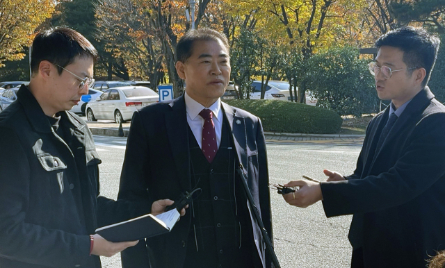 윤석열 대통령 부부 공천 개입 의혹 핵심 당사자인 명태균 씨 측 변호인 남상권 변호사(가운데)가 22일 오후 명 씨의 창원지검 소환 조사 입회에 앞서 취재진의 질문에 답하고 있다. 뉴스1