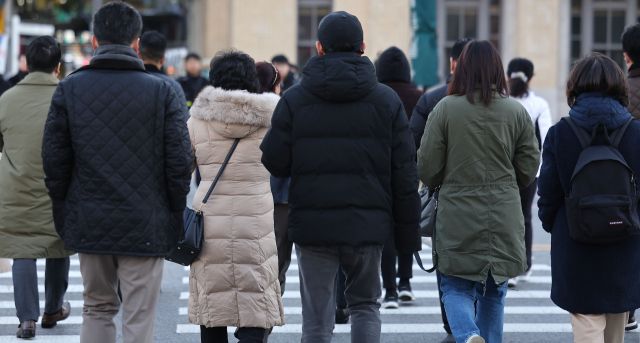 19일 오전 서울 광화문광장에서 시민들이 두꺼운 옷차림을 한 채 걸어가고 있다. 연합뉴스