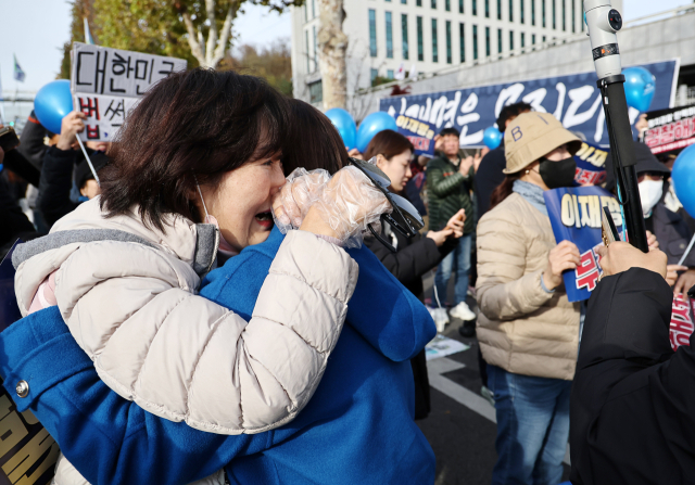 25일 오후 서울중앙지법에서 열린 더불어민주당 이재명 대표의 ‘위증교사 혐의' 사건 1심 선고가 무죄 판결되자 서울중앙지검 인근에서 지지자들이 기뻐하고 있다. 연합뉴스