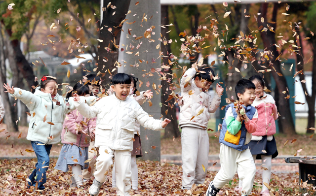 21일 광주 북구 용봉동 전남대학교 정문 5·18소공원으로 야외활동 나온 북구청 직장어린이집 아이들이 알록달록 물든 낙엽을 가지고 동심을 만끽하고 있다. 연합뉴스