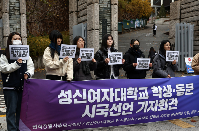 26일 서울 성신여자대학교 정문 앞에서 열린 성신여자대학교 학생·동문 시국선언 기자회견에서 성신여대 민주동문회를 비롯한 참석자들이 ‘윤석열 대통령 탄핵’등을 촉구하는 내용의 피켓을 들고 있다. 연합뉴스