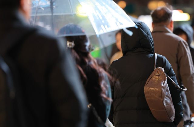 기온이 떨어진 이달 26일 오후 서울 세종대로사거리에서 두꺼운 옷을 입은 시민들이 이동하고 있다. 27일인 오늘은 전국에 비 또는 눈이 내리고 바람이 강하게 불어 체감온도가 더욱 낮을 것으로 보인다. 연합뉴스