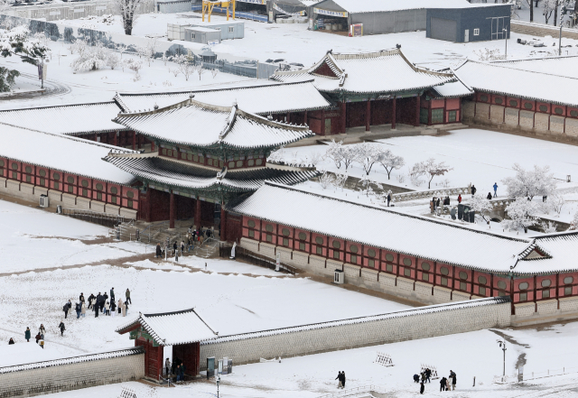 서울 지역에 폭설이 내린 27일 오전 서울 종로구 경복궁에서 시민들이 산책을 즐기고 있다. 연합뉴스