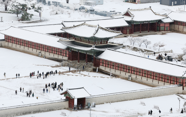 서울 지역에 폭설이 내린 27일 오전 서울 종로구 경복궁에서 시민들이 산책을 즐기고 있다. 연합뉴스