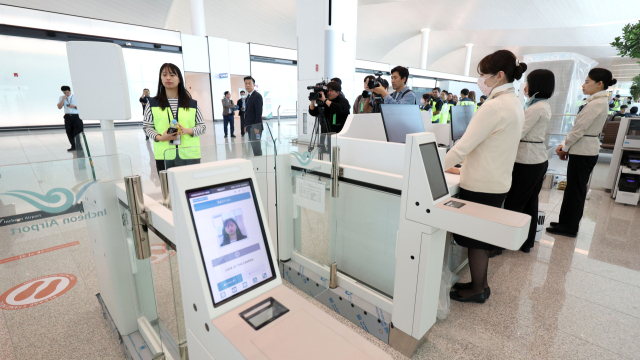 인천공항 제2여객터미널 4단계 확장 현장에서 지난달 30일 열린 종합시험운영에서 가상승객들이 셀프 보딩 시스템을 통해 신원을 확인하고 있다. 연합뉴스