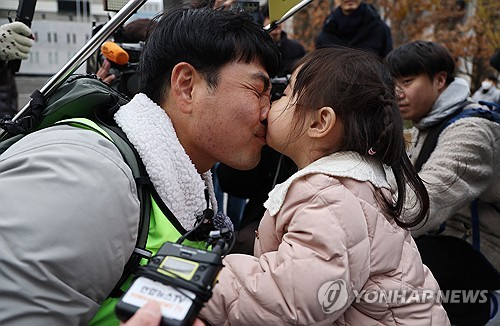 국내에는 치료법이 없는 희귀병을 앓고 있는 네 살 딸 사랑이의 치료비용을 위해 전국 곳곳을 돌며 후원을 요청하고 있는 전요셉 씨가 29일 오후 최종 목적지인 서울 광화문광장에 도착, 마중 나온 사랑이와 뽀뽀를 하고 있다. 연합뉴스