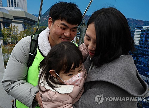 국내에는 치료법이 없는 희귀병을 앓고 있는 네 살 딸의 치료비용을 위해 전국 곳곳을 돌며 후원을 요청하고 있는 전요셉 씨가 29일 오후 서울 광화문광장에 도착, 부인 이상아 씨, 딸 사랑이와 함께 소감을 밝히고 있다. 연합뉴스