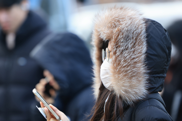 전국 대부분의 아침 기온이 영하로 떨어진 29일 오전 서울 세종대로사거리에서 두꺼운 옷을 입은 시민이 횡단보도를 건너고 있다. 연합뉴스