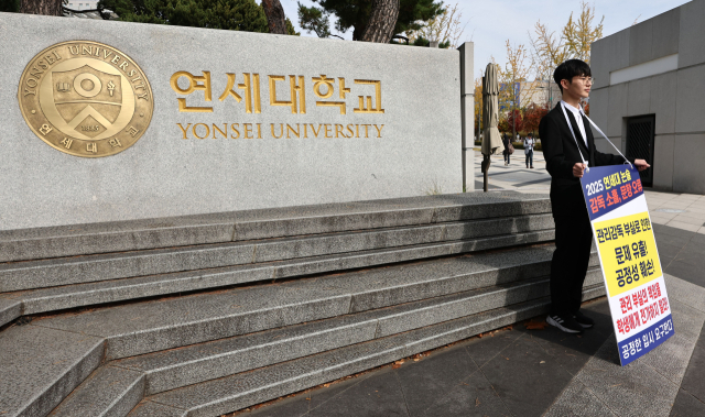 지난달 4일 서울 서대문구 연세대학교 정문 앞에서 연세대 재시험 집단소송의 후원자 중 한 명인 정모씨가 논술문제 유출 등을 규탄하며 1인 시위를 하고 있다. 연합뉴스