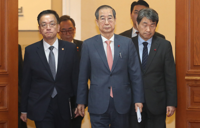 한덕수(가운데) 국무총리와 국무위원들이 비상계엄이 해제된 4일 서울 종로구 정부서울청사에서 현안 관련 긴급 회의를 마친 뒤 국무회의실을 나서고 있다. 뉴스1