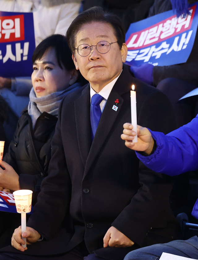 더불어민주당 이재명 대표가 4일 서울 여의도 국회에서 열린 '윤석열 대통령 사퇴촉구 탄핵추진 범국민 촛불문화제'에서 촛불을 들고 있다. 연합뉴스