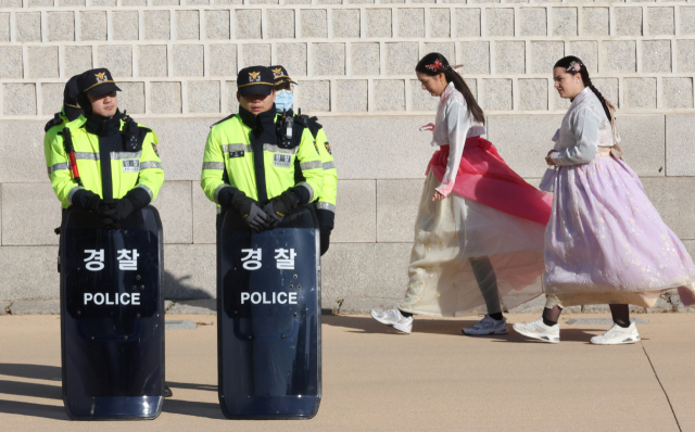 4일 외국인 관광객들이 한복을 입고 경복궁 담벼락을 지나가고 있다./연합뉴스