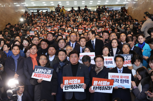 6일 오후 국회 로텐더홀에서 야당 의원들이 '윤석열을 탄핵하라!'라고 적힌 손팻말을 들고 있다. 연합뉴스