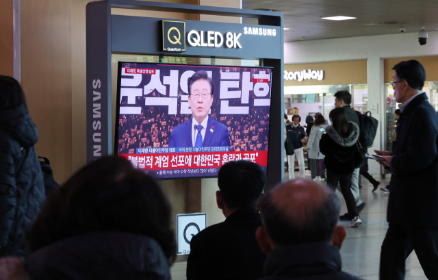 6일 서울역에서 시민들이 더불어민주당 이재명 대표 비상계엄 사태 관련 특별성명을 TV로 보고 있다. 연합뉴스