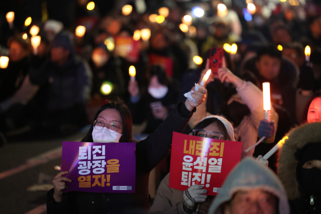 6일 오후 서울 영등포구 국회의사당역 인근에서 시민들이 대통령 탄핵을 촉구하는 촛불집회에 참석하고 있다. 연합뉴스