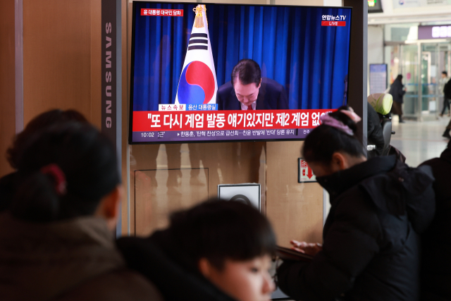 윤석열 대통령 탄핵소추안 표결이 예정된 7일 오전 서울역 대합실에서 시민들이 대통령 대국민 담화 중계를 지켜보고 있다. 연합뉴스