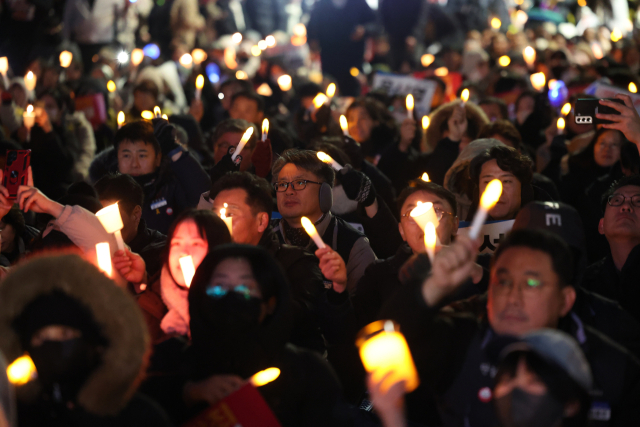 6일 오후 서울 영등포구 국회의사당역 인근에서 시민들이 대통령 탄핵을 촉구하는 촛불집회에 참석해 있다. 연합뉴스