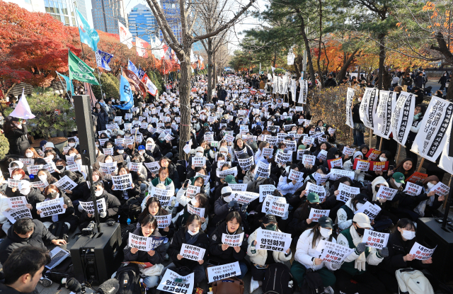 7일 오후 서울 영등포구 여의도 산업은행 본점 인근에서 열린 '윤석열 퇴진 대학생 시국대회'에서 대학생들이 비상계엄을 선포한 대통령의 퇴진을 촉구하며 손팻말을 흔들고 있다. 연합뉴스