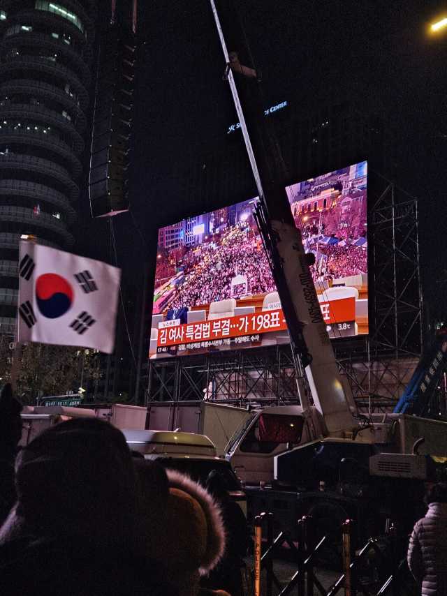 7일 서울 광화문 일대에서 보수단체가 윤석열 대통령 탄핵 반대 집회를 연 가운데, 김건희 여사 특검법 부결 소식이 전해지자 태극기를 흔들며 환호하고 있다. 박민주 기자