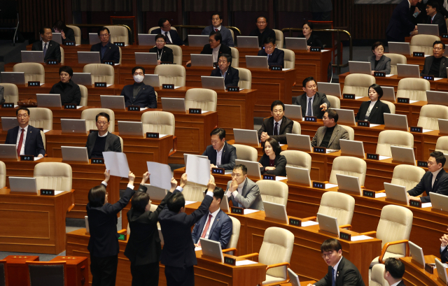 7일 국회 본회의장에서 진보당 의원이 윤석열 대통령 처벌 촉구 팻말을 들고 있다. 이날 본회의는 윤 대통령 탄핵소추안과 김건희 여사 특검법을 표결할 예정이다. 연합뉴스