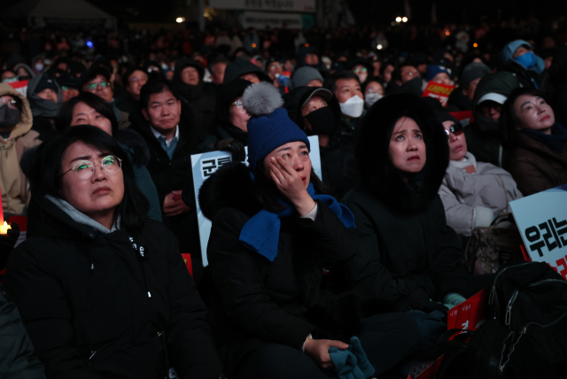 7일 오후 서울 여의도 국회 앞에서 열린 '내란죄 윤석열 퇴진! 국민주권 실현! 사회대개혁! 범국민촛불대행진'에서 한 참석자가 눈물을 흘리고 있다. 연합뉴스