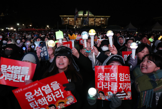 7일 오후 서울 여의도 국회 앞에서 열린 '내란죄 윤석열 퇴진! 국민주권 실현! 사회대개혁! 범국민촛불대행진'에서 응원봉을 든 참가자들이 탄핵안 통과를 촉구하고 있다. 연합뉴스