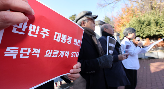 서울의대·병원 교수 비상대책위원회가 6일 서울 종로구 서울대학교 의과대학 앞에서 열린 대통령 탄핵 요구 및 합의 없는 의료개혁 멈춤을 주제로 합동 기자회견에서 손피켓을 들고 있다. 뉴스1