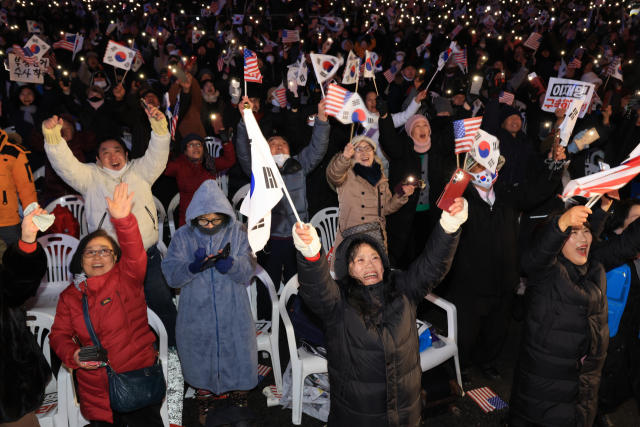 7일 서울 광화문 동화면세점 앞에서 대한민국바로세우기국민운동본부 주최로 열린 ‘자유 대한민국 수호 광화문 국민혁명대회’ 참가자들이 김건희 여사 특검법 부결과 대통령 탄핵소추안에 관한 소식을 듣고 기뻐하고 있다. 연합뉴스