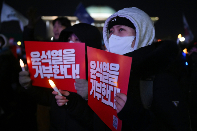 ‘내란죄 윤석열 퇴진! 국민주권 실현! 사회대개혁! 범국민촛불대행진’ 참가자들이 7일 서울 여의도 국회 앞에서 대통령 퇴진을 촉구하며 손팻말을 든 채 표결 상황을 지켜보고 있다. 조태형 기자