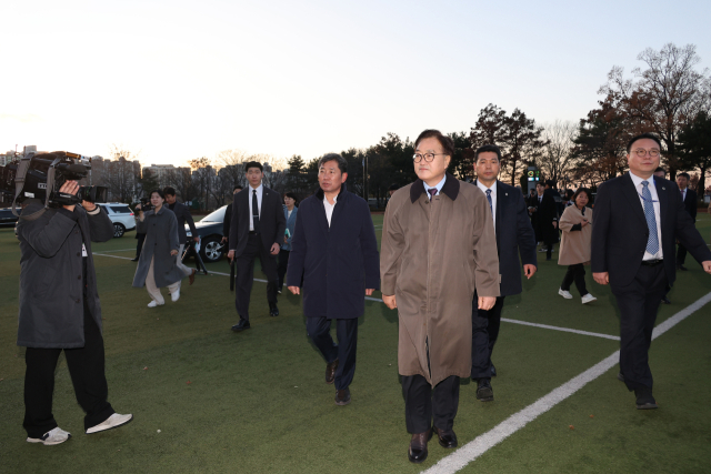 우원식 국회의장이 6일 오후 서울 여의도 국회 운동장에서 헬기 착륙 방지 목적으로 주차된 차량 배치 상황을 살펴본 뒤 이동하고 있다. 연합뉴스