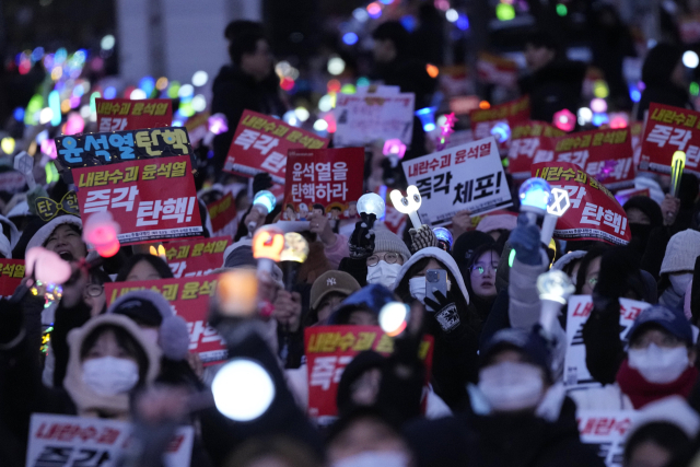 8일 서울 국회의사당 앞에서 열린 윤석열 대통령 탄핵 촉구 집회에서 참가자들이 피켓과 응원봉을 흔들고 있다. AP연합뉴스