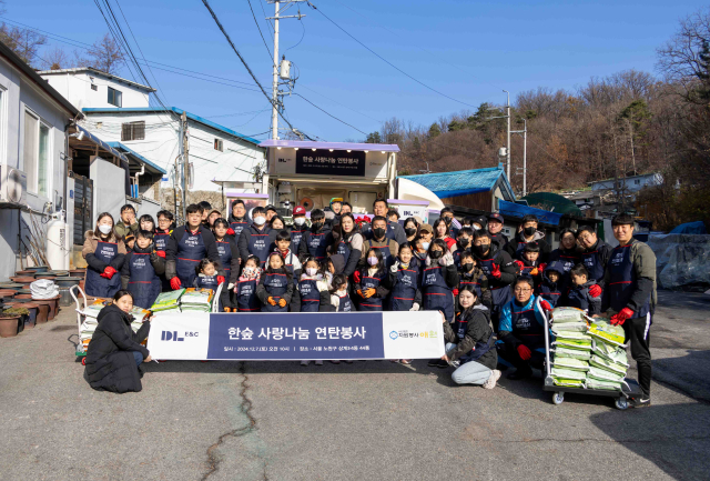 DL이앤씨 임직원 가족들이 서울 노원구 상계동에서 ‘사랑나눔 연탄 봉사활동’을 마친 뒤 기념촬영을 하고 있다. 사진 제공=DL이앤씨