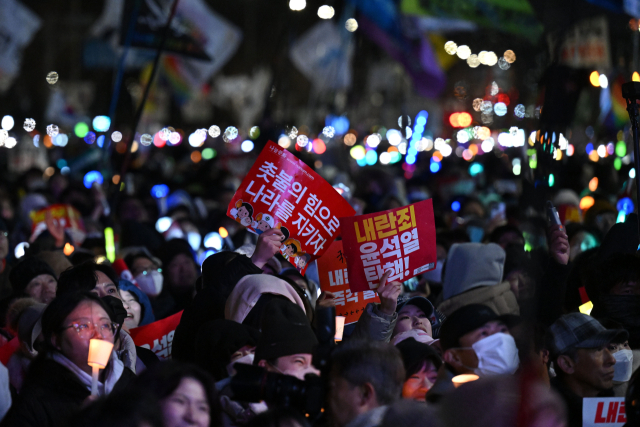 '내란죄 윤석열 퇴진! 국민주권 실현! 사회대개혁! 범국민촛불대행진' 참가자들이 7일 서울 여의도 국회 앞에서 대통령 퇴진을 촉구하며 촛불과 K-팝 아티스트 응원봉 등을 밝힌 채 손팻말을 들고 있다. 조태형 기자