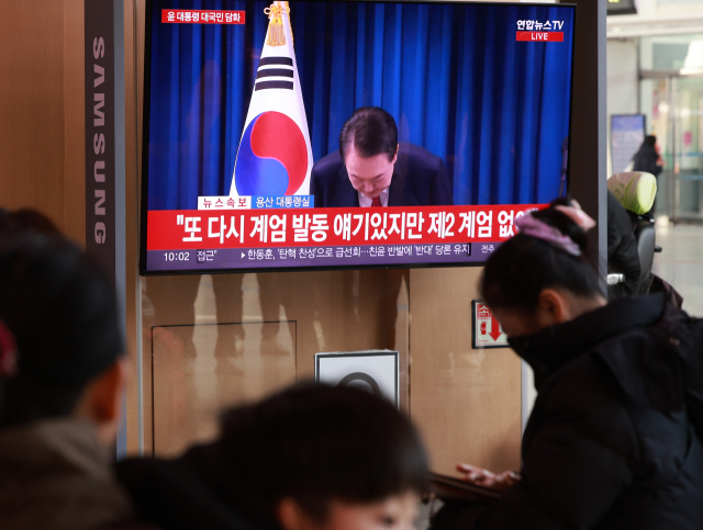 윤석열 대통령 탄핵소추안 표결이 예정된 7일 오전 서울역 대합실에서 시민들이 대통령 대국민 담화 중계를 지켜보고 있다. 연합뉴스