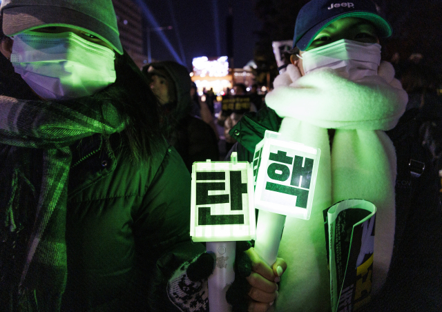 비상계엄 후폭풍이 계속되고 있는 11일 국회 앞에서 열린 윤석열 대통령 탄핵 촉구 촛불 집회 참가 시민들이 촛불과 응원봉을 들고 국민의힘 당사를 향해 행진하고 있다. 연합뉴스