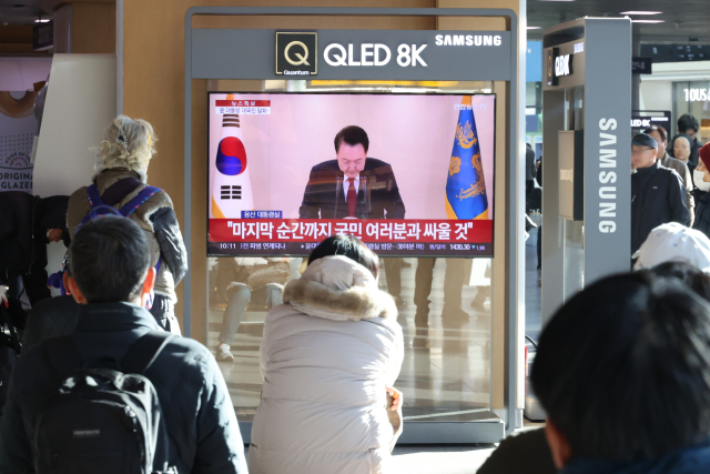대통령 대국민 담화 중계 (서울=연합뉴스) 이진욱 기자 = 12일 오전 서울역에서 시민들이 윤석열 대통령 담화를 TV로 보고 있다. 연합뉴스