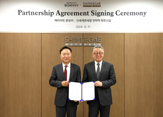 유신열(오른쪽) 신세계디에프 대표와 남기덕 메리어트 인터내셔널 한국·필리핀·베트남 지역 담당 대표가 11일 협약식을 맺고 기념 촬영하고 있다. 사진 제공=신세계디에프