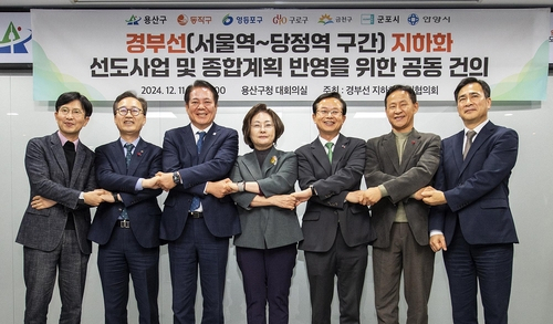 서울과 경기의 7개 기초단체장들이 지난 11일 용산구청에서 열린 경부선 지하화 추진협의회 회의에서 손을 맞잡고 있다. 사진 제공=용산구