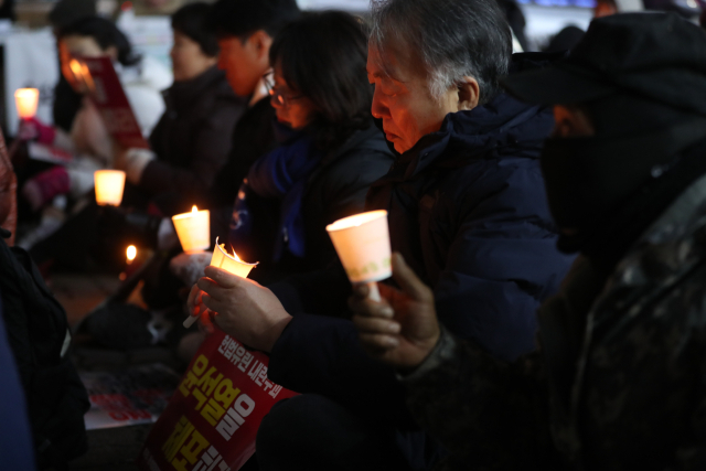윤석열 정권 퇴진을 촉구하는 촛불집회가 열려 시민들이 피켓과 촛불을 들고 있다. 연합뉴스
