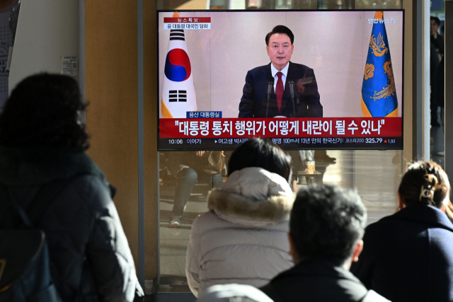 12일 서울역에서 시민들이 TV로 윤석열 대통령의 대국민 담화를 시청하고 있다. 조태형 기자