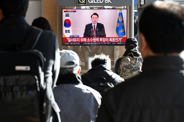 12일 서울역에서 시민들이 TV로 윤석열 대통령의 대국민 담화를 시청하고 있다. 조태형 기자