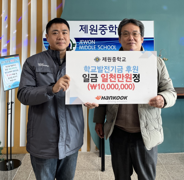 김진영(사진 왼쪽) 한국타이어 금산공장 경영관리팀 책임과 안문기 제원중학교 교장이 11일 학교발전기금 전달식에서 기념 촬영을 하고 있다. 사진 제공=한국타이어