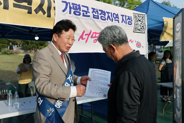 서태원 가평군수가 접경지역 지정을 위한 범군민 서명운동 자리에서 군민들에게 제도 취지를 설명하고 있다. 사진 제공=가평군