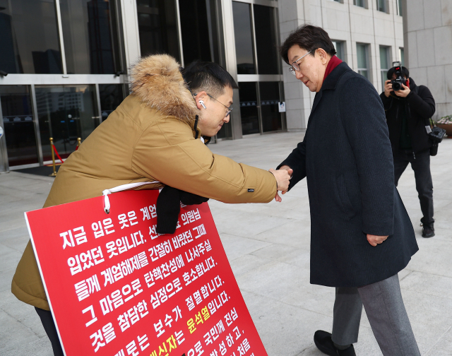 권성동 국민의힘 원내대표가 13일 오전 국회 본청 앞에서 탄핵 찬성을 호소하는 김상욱 의원과 악수하고 있다. 연합뉴스