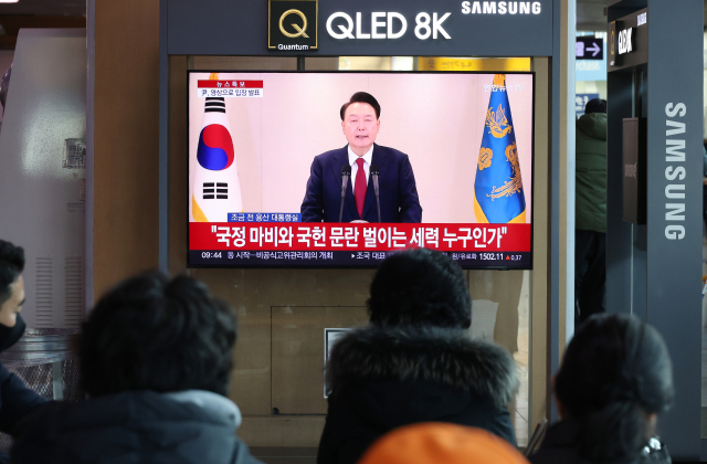 12일 서울역에서 시민들이 윤석열 대통령 담화를 TV로 보고 있다. 연합뉴스