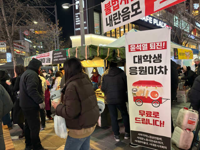 13일 서울 서대문구 신촌 연세로에서 열린 ‘윤석열 대통령 불법계엄 규탄 및 퇴진 요구를 위한 전국 대학생 총궐기 집회’ 인근에서 무료 떡볶이·오뎅 포장마차가 운영되고 있다. 정다은 기자