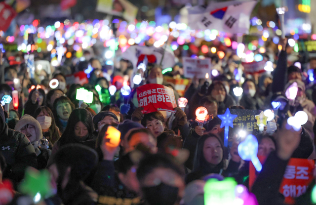 지난 12일 서울 영등포구 국회 앞에서 열린 윤석열 대통령 탄핵 촉구 촛불 집회에 참석한 시민들이 응원봉을 흔들며 구호를 외치고 있다. 연합뉴스