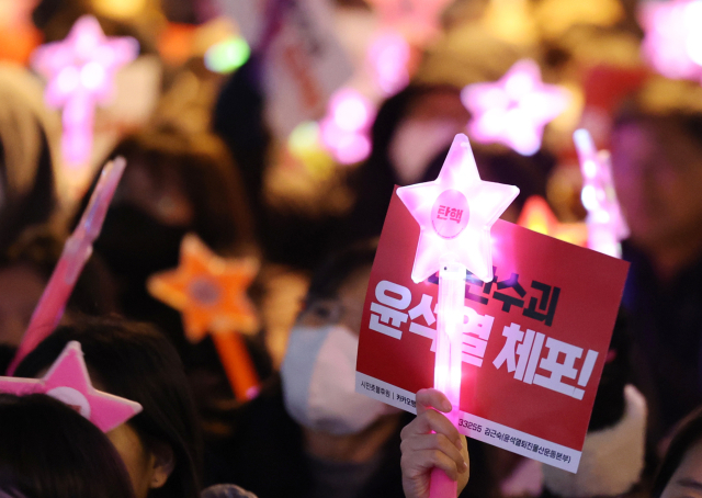 13일 오후 울산시 남구 롯데백화점 앞 광장에서 열린 '울산시민대회'에 참가한 시민이 피켓과 야광봉을 흔들며 윤석열 대통령의 탄핵을 촉구하는 구호를 외치고 있다. 연합뉴스